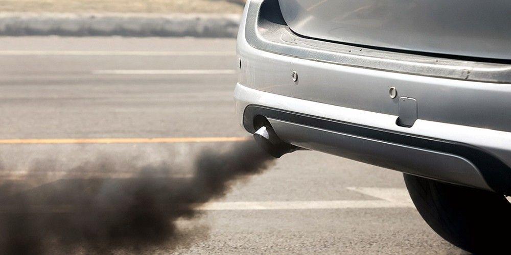 Car exhaust pipe emitting thick black smoke on the road.